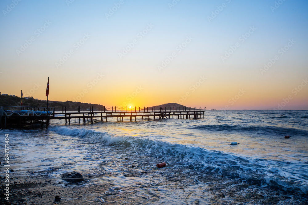 Wooden pier bridge in the blue sea in afternoon sunset