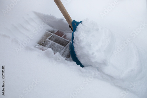 Cleaning snow with shovel in winter day