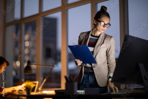 Behang Young attractive businesswoman bending over workplace while looking at computer