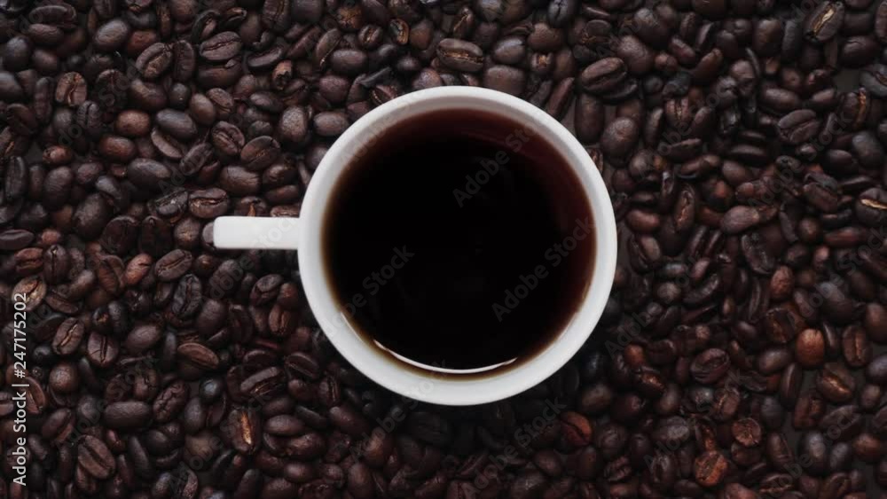 Loopable Cinemagraph of Cup of Coffee among Coffee Beans. Top View Loopable Cinemagraph of Cup of Coffee among Coffee Beans. Top View