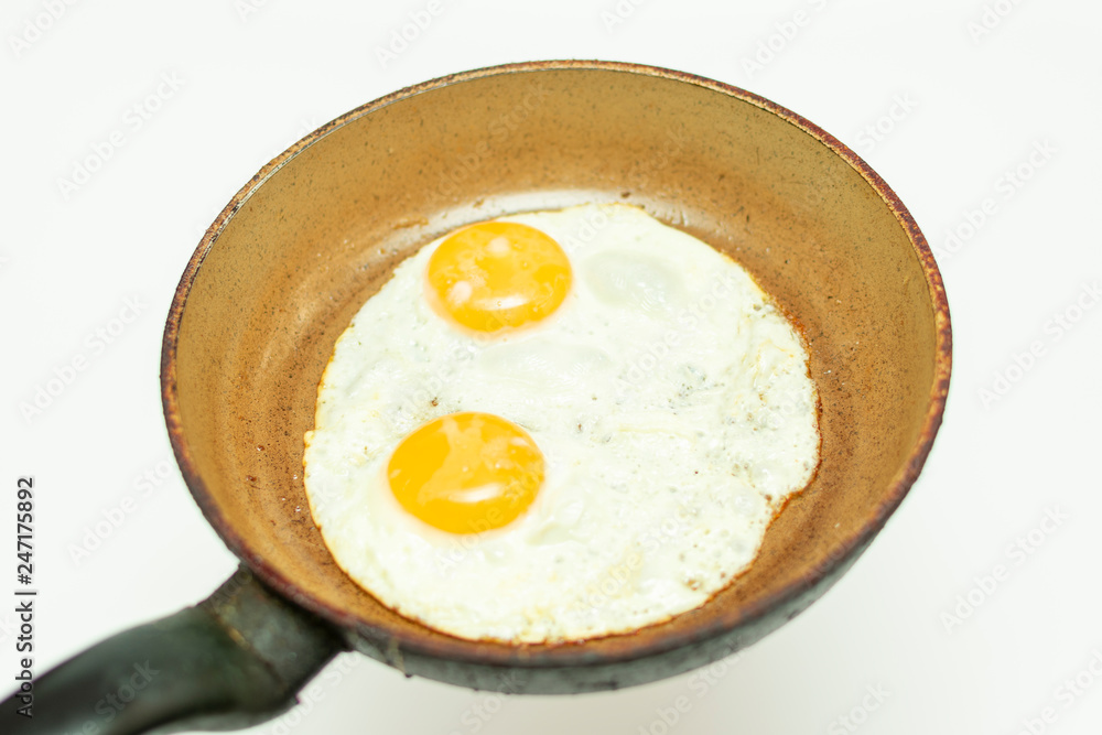 fried eggs from two eggs in a pan isolated on white background fried eggs from two eggs in a pan isolated on white background