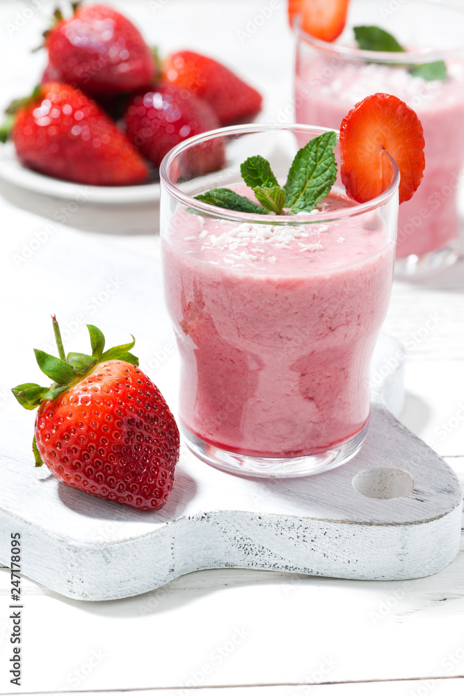 refreshing strawberry milkshake on white table, vertical refreshing strawberry milkshake on white table, vertical