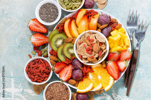 plate of fresh seasonal fruits and superfoods on rustic background, top view
