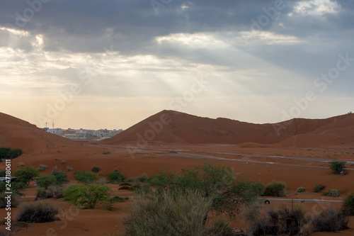 Sun rays pierce the stormy clouds above the sand dunes in the UAE.