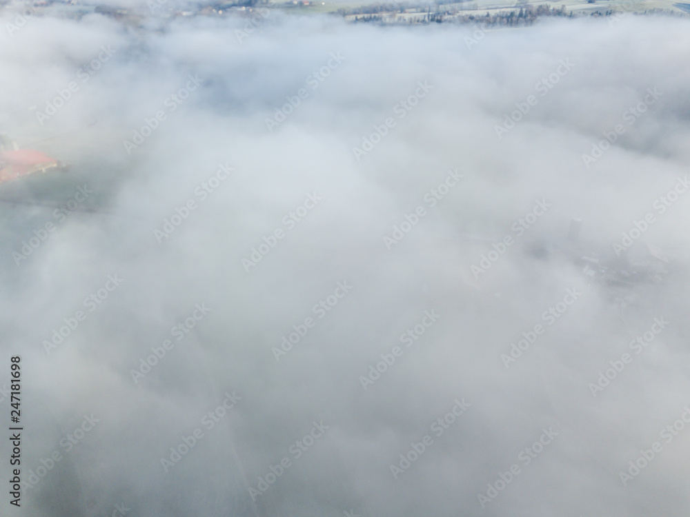Aerial view of rural landscape in Switzerland covered with fog. Cold morning in winter with beautiful light.