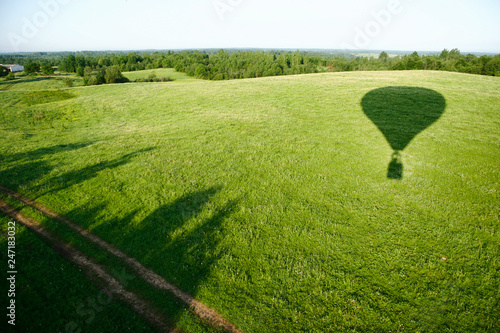 The shadow of the balloon on the background of a green meadow.
