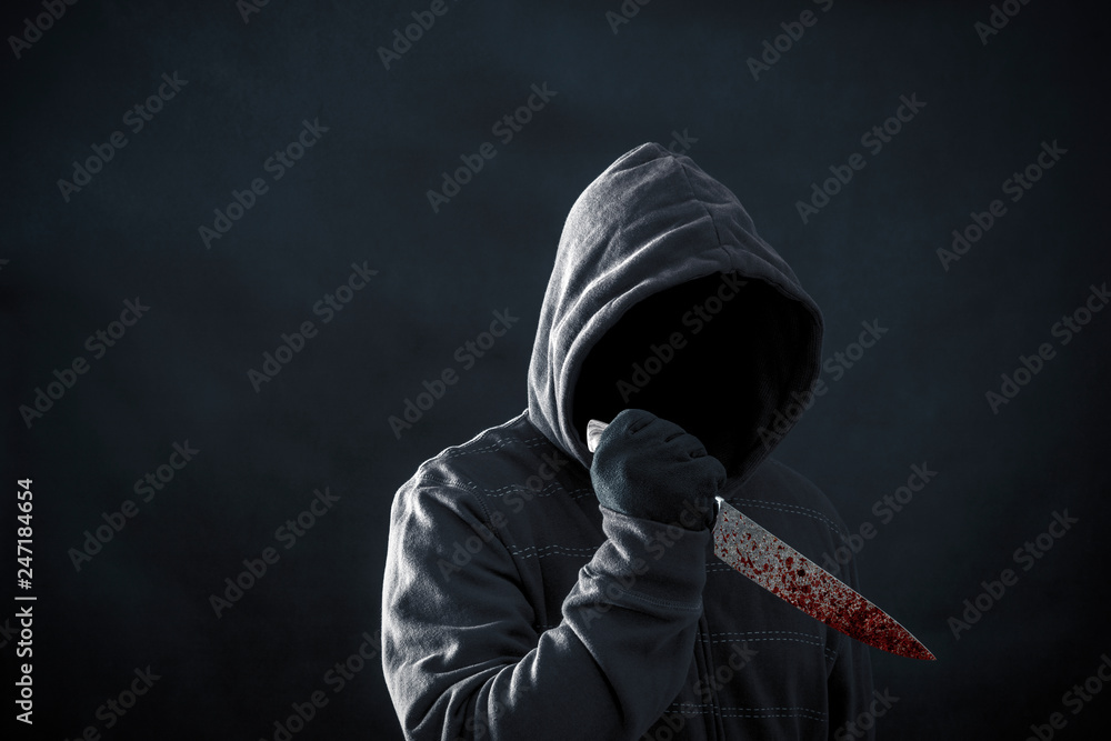 © Jakub Krechowicz - Hooded man with bloody knife in the dark