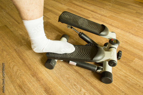 Men's Legs in white socks stand on a stepper (side view)