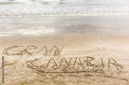 Die Worte Gran Canaria in den Sand des Strandes geschrieben