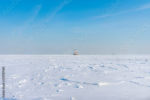 Lake Michigan in Chicago Frozen Over with Snow after a Polar Vortex with a Lighthouse in the distance