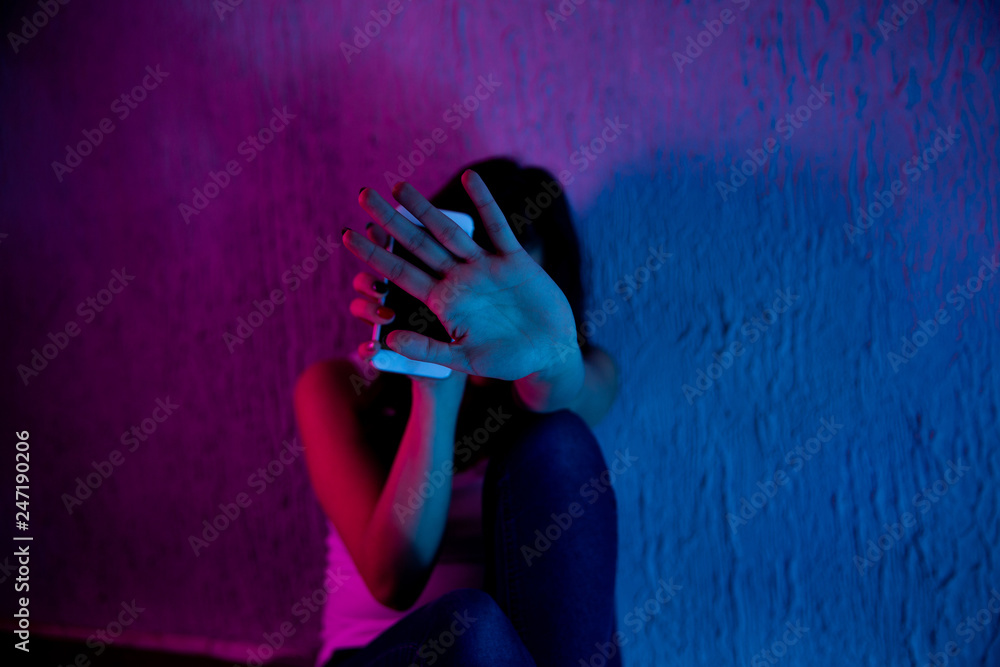 Wall Mural scared and sad female teenager with computer laptop suffering cyberbullying and harassment being online abused by stalker or gossip feeling desperate and humiliated in cyber bullying
