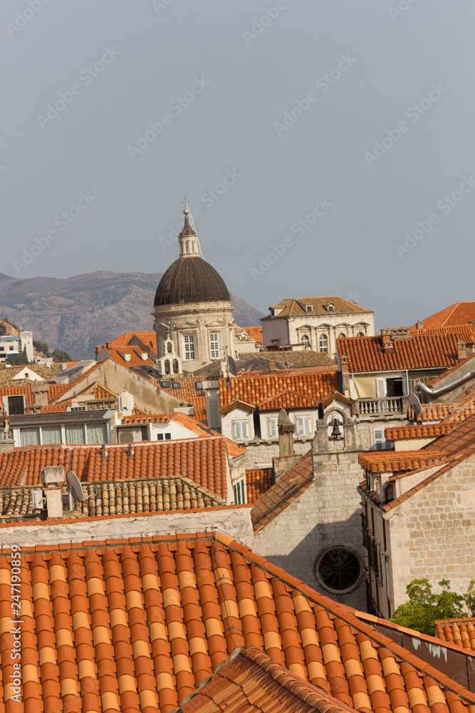 DUBROVNIK, CROATIA - AUGUST 22 2017: View from the top of town walls of Dubrovnik roofs, with Cathedral dome