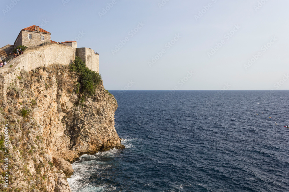 DUBROVNIK, CROATIA - AUGUST 22 2017: Dubrovnik defensive stone walls  overlooking the cliff and sea horizon