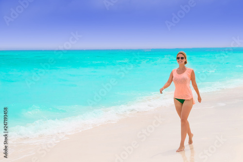 Gorgeous woman on the sandy beach with turquoise ocean