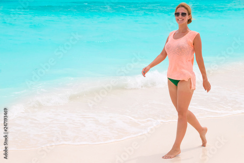 Gorgeous woman on the sandy beach with turquoise ocean