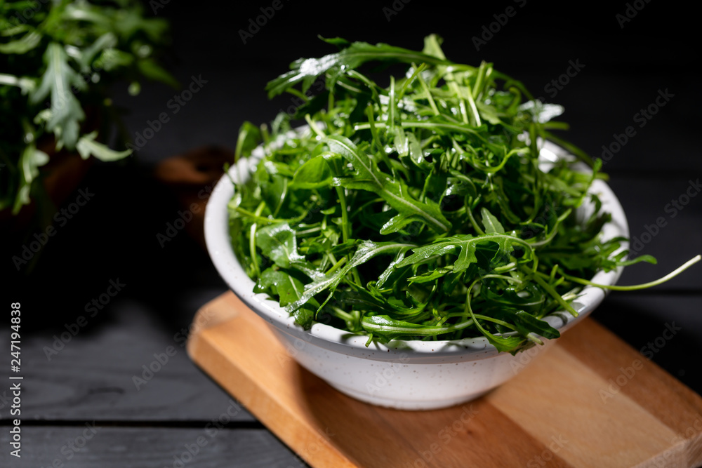 Fresh rocket salad in bowl on the wodden background Fresh rocket salad in bowl on the wodden background