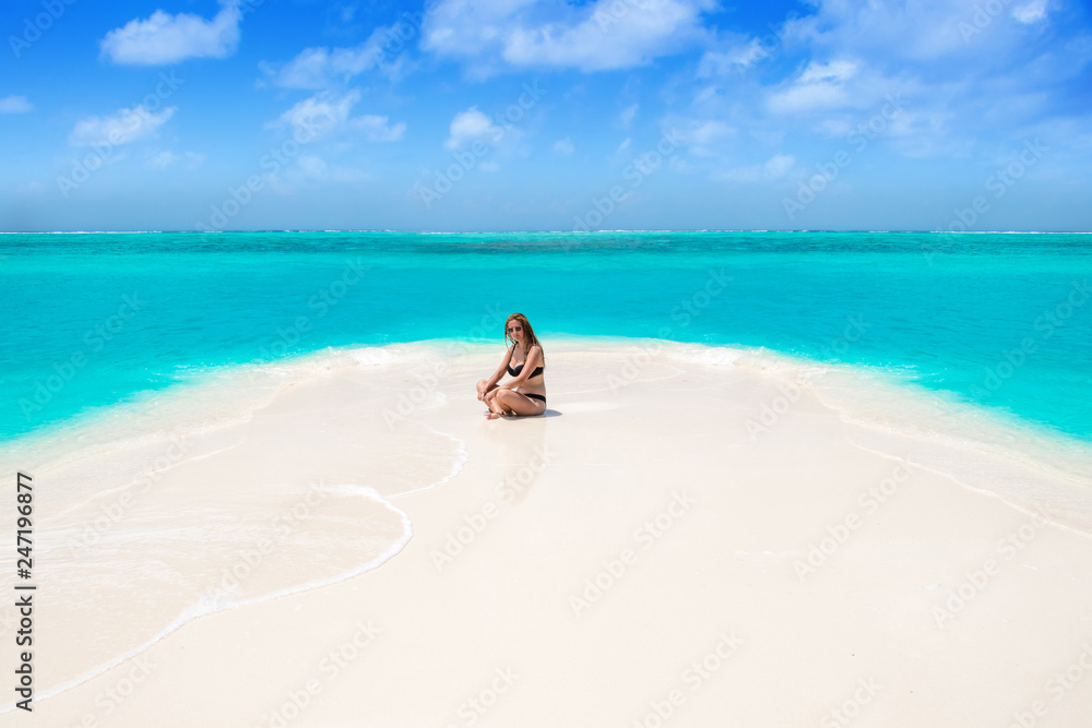 Obraz premium Blonde Girl in black bikini on dream beach at the turquoise ocean