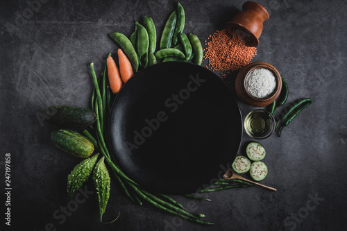 Various fresh vegetables on a black table with space for a message