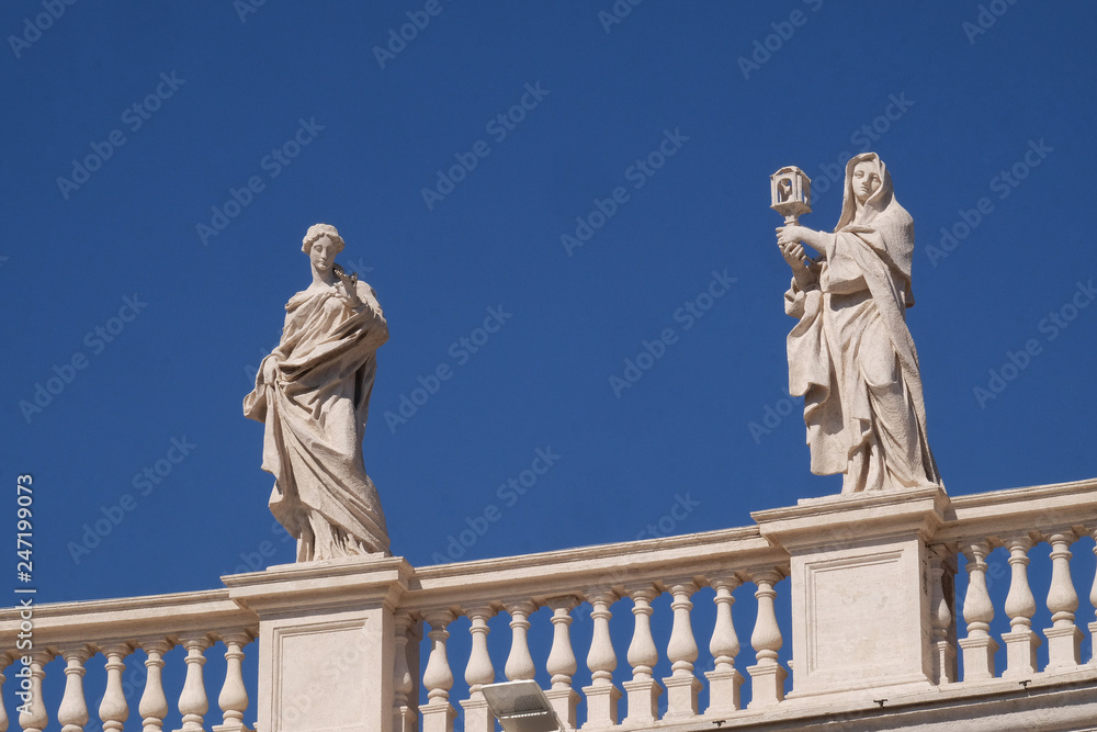 St. Olympias and St. Clare of Assisi, fragment of colonnade of St. Peters Basilica. Papal Basilica of St. Peter in Vatican - the world largest church, is the center of Christianity in Rome, Italy 