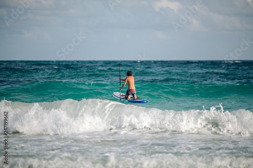 Man sails surfing on the waves in the Caribbean, in Cancun, Mexico