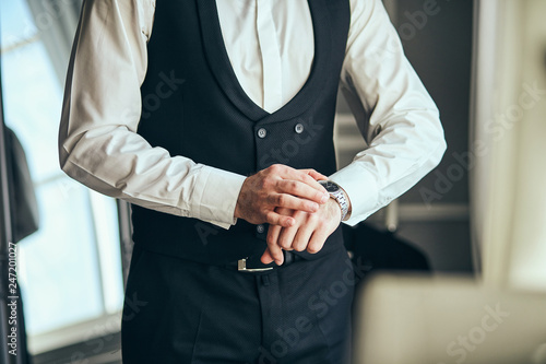 businessman checking time on his wrist watch, man putting clock on hand,groom getting ready in the morning before wedding ceremony. Men Fashion