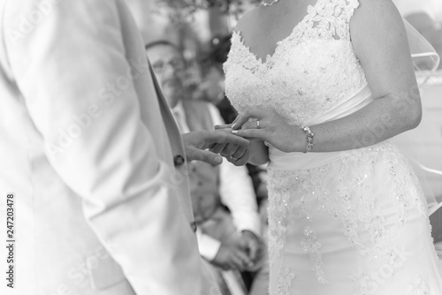 Bride & groom placing rings on fingers during the wedding ceremony