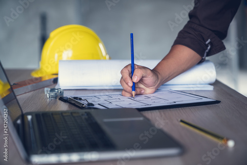 Architect & Engineer working drawing document about project planning and progress of work schedule on the home building construction site
