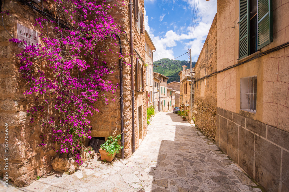 Fototapeta Valldemossa zachwyca ulice ozdobione doniczkami i kolorowymi kwiatami