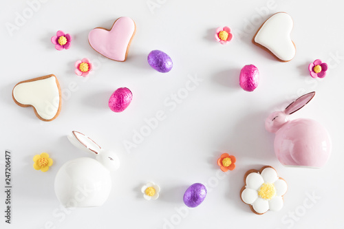 Easter eggs, cookies, sweets, porcelain rabbit, easter decorations on white background. Minimum Easter holiday concept. Flat lay, top view, copy space