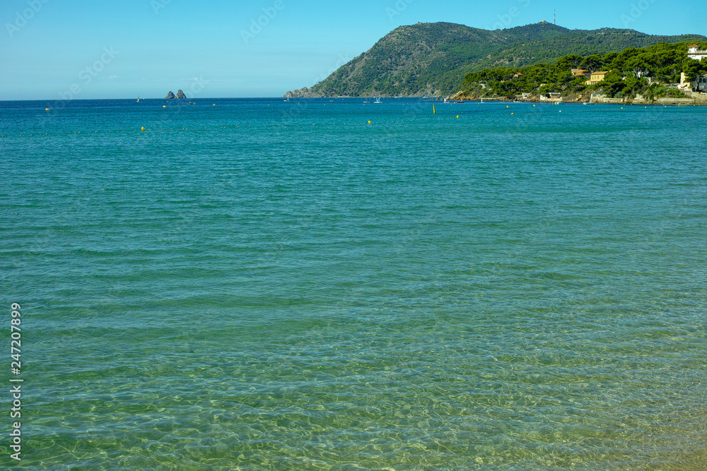 Obraz premium Sunny sandy beach vacation, landscape with clear blue sea shore and sandy beach