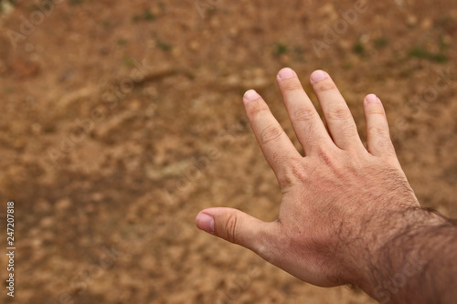 A human hand with an earthy background. Man and nature concept image.  © MATTHEW