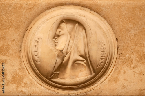 Saint Clare of Assisi, bass relief in portico of church dei Santi XII Apostoli in Rome, Italy 