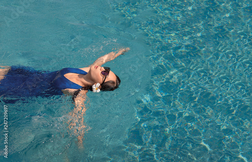 asian girl with swimming suite and sun glasses on pool