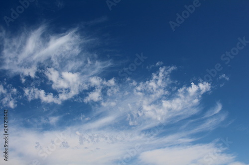 Wispy cirrus clouds against a blue sky.