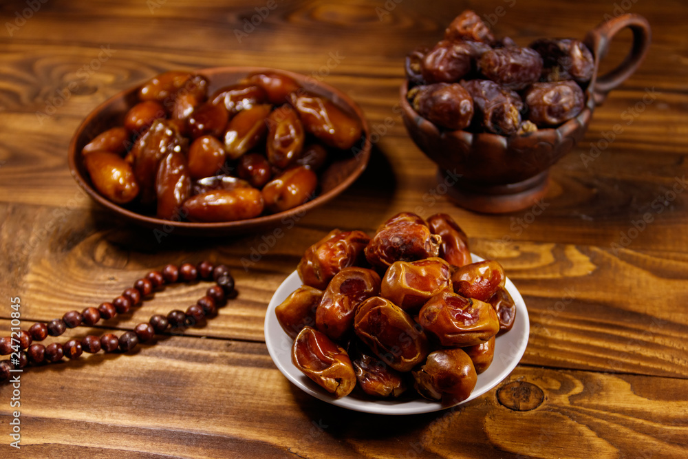 Dates fruit and rosary on wooden table Dates fruit and rosary on wooden table
