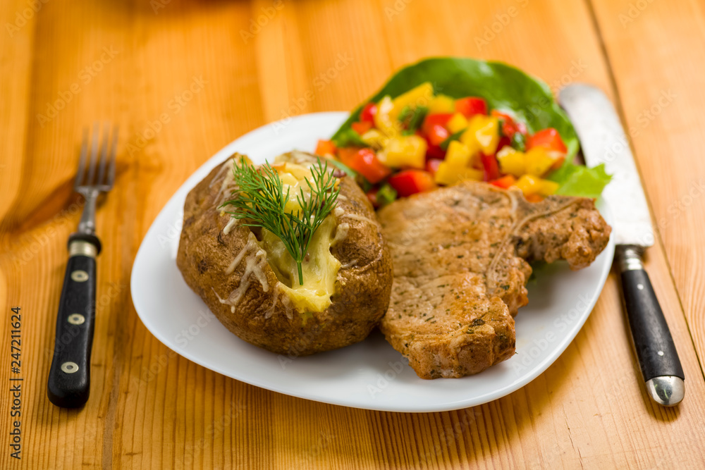 roasted pork chop and potatoes with stuffed skin