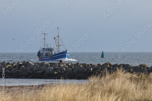traditional blue fishing vessel enters the harbor