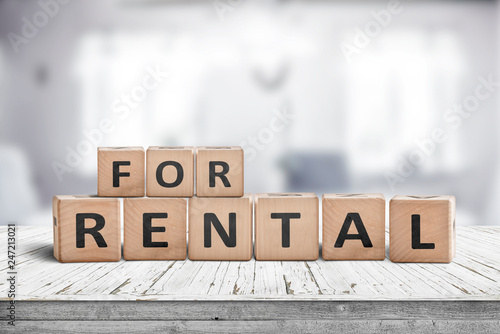Sign with the text for rent on a desk
