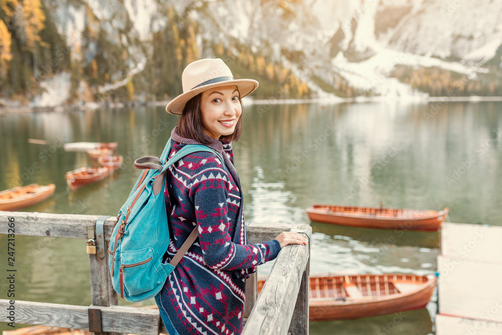 Asian woman traveler on the shore of the famous tourist lake Braies in the Dolomites Alps, Italy. The concept of travel and adventure in the mountains at autumn season Asian woman traveler on the shore of the famous tourist lake Braies in the Dolomites Alps, Italy. The concept of travel and adventure in the mountains at autumn season