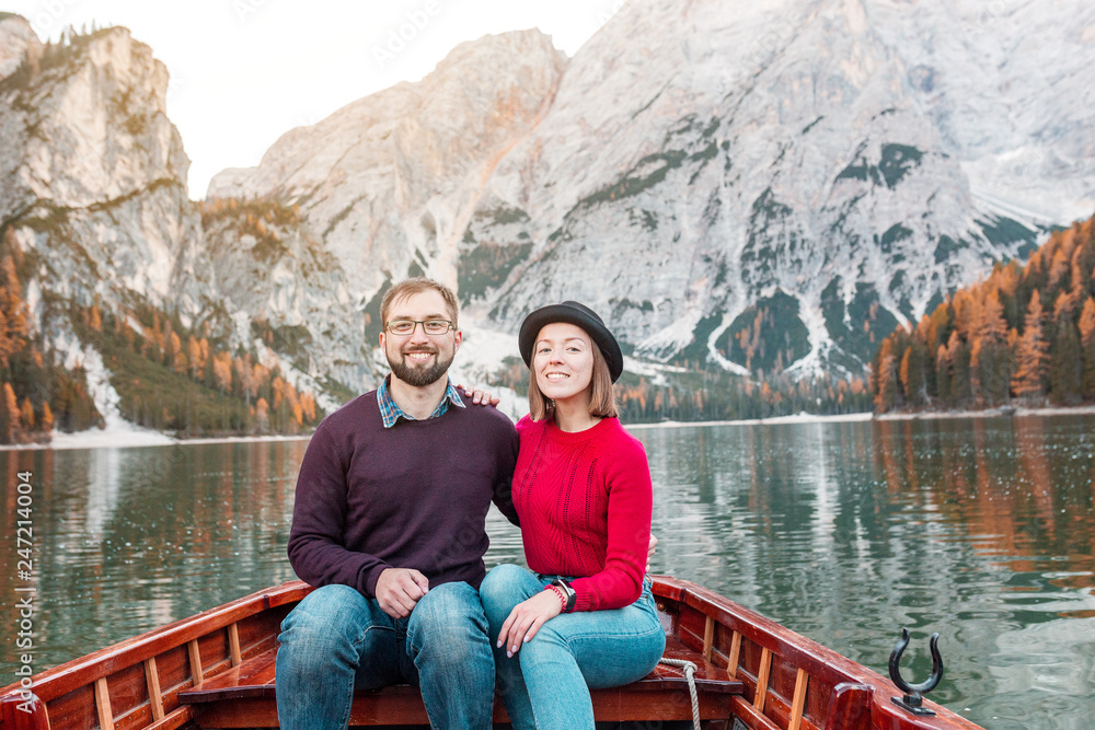 Couple young man and woman together on the boat or canoe cruise tour on well known Braies lake in Italian Dolomites Alps. Travel and love concept Couple young man and woman together on the boat or canoe cruise tour on well known Braies lake in Italian Dolomites Alps. Travel and love concept