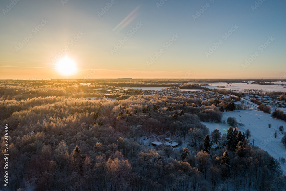 Fototapeta premium Aerial view of a beautiful sunset in the winter forest.