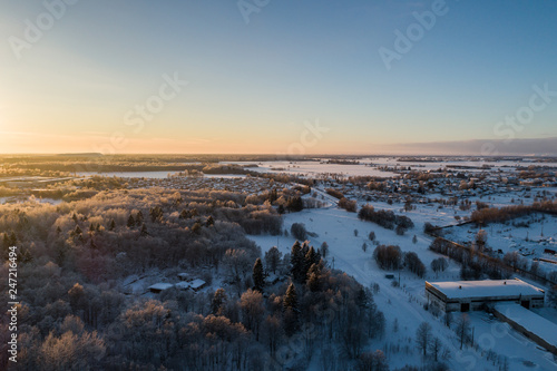 Aerial view of a beautiful sunset in the winter forest. © nikwaller