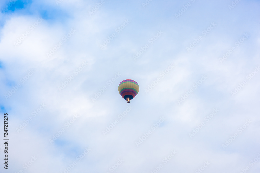 Hot air balloons fly over the sky.