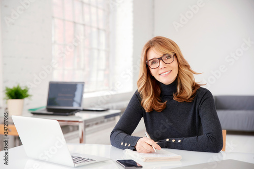 Businesswoman sitting at office desk and doing some paperwork