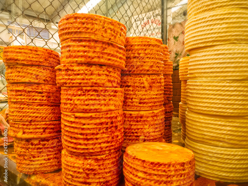 Stacks of cheese wheels cheese truckles. Queso de Cincho (Queso Guerrero) Cincho Cheese for sale in a market in Iguala, Guerrero. Travel in Mexico, Mexican food, firm cheese. photo