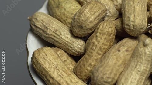 Wallpaper Mural Raw Inshell Peanuts in Rotation. peanuts in shell. Snack closeup.   Peanuts in a bowl. Selective focus. grey background. Studio shot. Healthy food concept. Torontodigital.ca