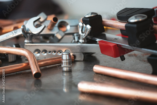 Fotografija Pipes, pipe bender and other pipework tools on a fitter workbench background