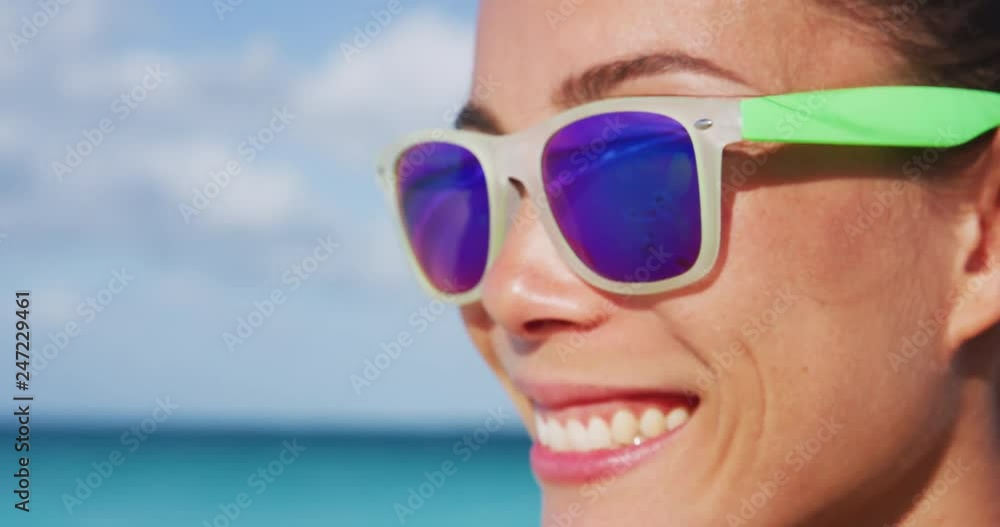 Smiling young sporty woman wearing purple sunglasses. Trendy female with fashionable eyewear during sunny day. She is enjoying at beach. RED Camera SLOW MOTION. Smiling young sporty woman wearing purple sunglasses. Trendy female with fashionable eyewear during sunny day. She is enjoying at beach. RED Camera SLOW MOTION.