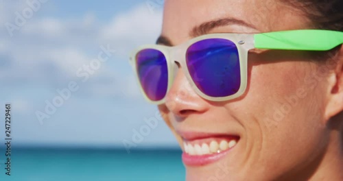 Wallpaper Mural Smiling young sporty woman wearing purple sunglasses. Trendy female with fashionable eyewear during sunny day. She is enjoying at beach. RED Camera SLOW MOTION. Torontodigital.ca