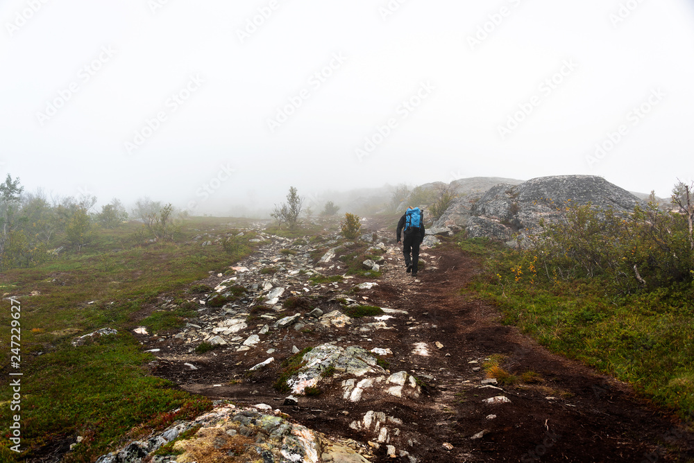 Hiker on foggy trail